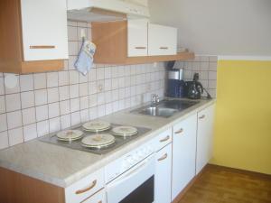 eine Küche mit Spüle und Herd oberen Backofen in der Unterkunft Ferienwohnung Fischenhaus, Familie Wesenauer in Mondsee