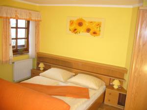 ein Schlafzimmer mit einem Bett und einer gelben Wand in der Unterkunft Ferienwohnung Fischenhaus, Familie Wesenauer in Mondsee