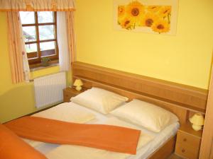 ein kleines Schlafzimmer mit einem Bett mit zwei Kissen in der Unterkunft Ferienwohnung Fischenhaus, Familie Wesenauer in Mondsee