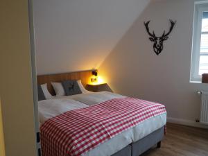 ein Schlafzimmer mit einem Bett und einem Hirschkopf an der Wand in der Unterkunft Hotel Neumaier in Xanten