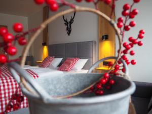 ein Schlafzimmer mit einem Bett mit roten Kissen und einer Pflanze in der Unterkunft Hotel Neumaier in Xanten
