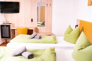 a room with two beds with pillows and a mirror at Waldhotel in Boizenburg