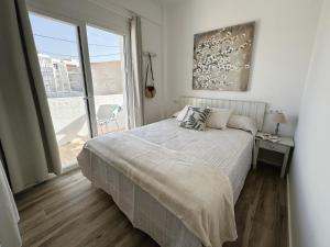 a bedroom with a bed and a large window at Apartamentos Sa Barda - Emar Hotels in Sant Ferran de Ses Roques