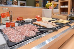 a counter with meat and cheese and other foods at easyHotel Nice Old Town in Nice