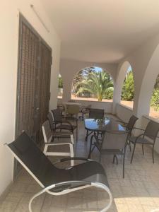 a room with chairs and tables and a balcony at Villa Rosetta, Gallipoli tra mare e natura in Pizzo +17 photos