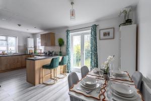 a kitchen and a dining room with a table and chairs at Spacious modern apartment in South Croydon in Purley