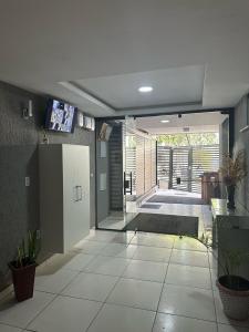 Una sala de estar con una puerta de vidrio y piso de baldosas. en Lindo apartamento - 3 min da praia do recreio, en Río de Janeiro
