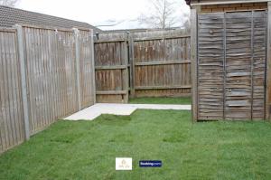 a backyard with a wooden fence and a lawn at 3 Bedroom House By Trinity Stays Short Lets & Serviced Accommodation Cambridge With Free WiFi & Parking in Cambridge