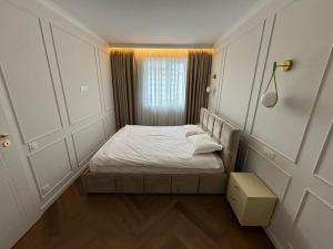 a small bedroom with a bed and a window at High Stay Suite Cluj in Floreşti