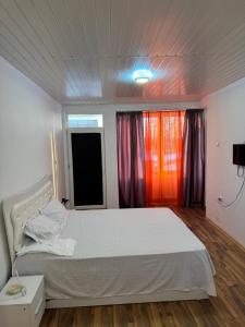 a bedroom with a white bed and a window at Cazare Magurele in Măgurele