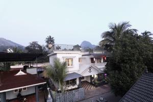 a large white house with palm trees in front of it at Natures Bliss in Anaviratty