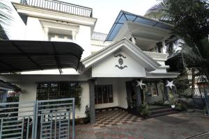 a white house with a gate in front of it at Natures Bliss in Anaviratty +5 photos