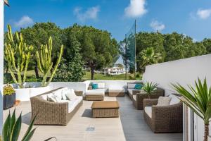 a patio with wicker chairs and couches and plants at Casa Angela 3 Bedrooms Penthouse Apartment in La Quinta Golf Marbella in Benahavís
