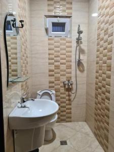 a bathroom with a toilet and a sink and a shower at Guest House Rustaveli in K'obulet'i