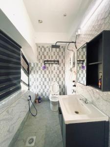 un baño con lavabo e inodoro en Hotel Casaria, en Paka
