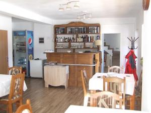 a kitchen and dining room with a table and chairs at Gentiana-Sureanu in Tău Bistra