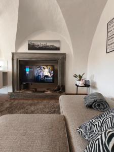 a living room with a fireplace with a tv at Il piazzolo, un angolo di storia in Carobbio degli Angeli
