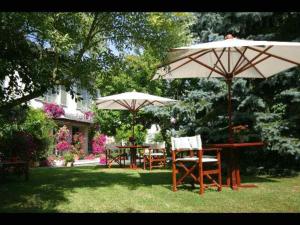 2 tables et chaises avec parasols dans la cour dans l'établissement Hôtel Beatus, à Cambrai