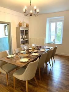 ein Esszimmer mit einem Holztisch und Stühlen in der Unterkunft Une histoire de famille in Écordal