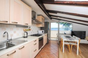 a kitchen with a sink and a table with chairs at Molet apartments Koper in Koper
