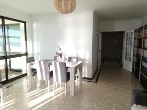 a dining room with a white table and chairs at Buarcos&Sea Accommodation - Cristal Mar - Your Panoramic Ocean View Retreat in Figueira da Foz
