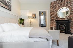 a bedroom with a white bed and a fireplace at The Merchant House in Dublin