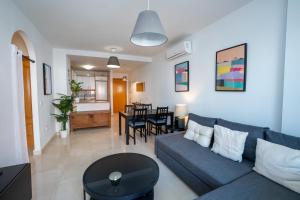 Una sala de estar con un sofá azul y una mesa. en NEPTUNO 2C MENYBER, en Nerja