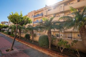 Un edificio con palmeras delante. en NEPTUNO 2C MENYBER, en Nerja