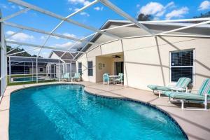 a swimming pool with two chairs and a patio at Orlando Theme Park Pool Homes in Kissimmee