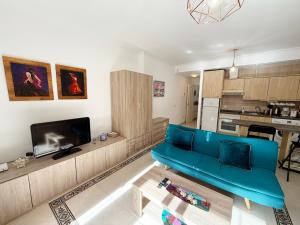 salon z niebieską kanapą i kuchnią w obiekcie Suite Maimonides Fuengirola w mieście Fuengirola