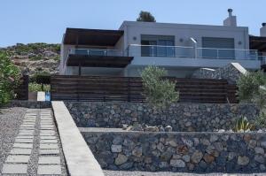 a house on a hill with a stone wall at Pefkos Heights Private Pool Villa in Pefki Rhodes