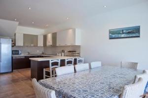 a kitchen with a table and chairs and a kitchen with a counter at Pefkos Heights Private Pool Villa in Pefki Rhodes +12 photos