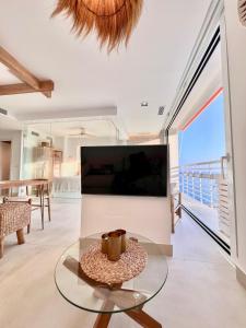 sala de estar con mesa de cristal frente a una TV en NATuRaL BEACH HOME, en Torremolinos