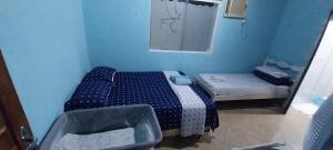 a small blue room with a bed and a window at CASA DE HOSPEDAGEM PARATY 10 MINUTOS DO CENTRO COM OPÇÕES DE CAFÉ da MANHÃ in Paraty
