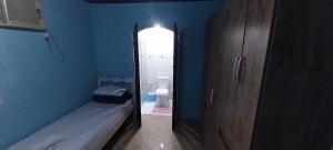 a bathroom with a toilet and a blue wall at CASA DE HOSPEDAGEM PARATY 10 MINUTOS DO CENTRO COM OPÇÕES DE CAFÉ da MANHÃ in Paraty