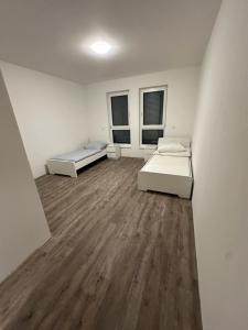 a white room with two beds and two windows at Wunderschöne Ferienwohnung in Leipzig Taucha 1 OG rechts in Taucha