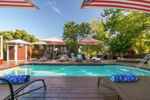 a swimming pool with chairs and an umbrella at Knysna - Oyster Catcher in Knysna