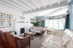 Una sala de estar con un sofá y una chimenea. en Blue Bay Beach House, en Newquay