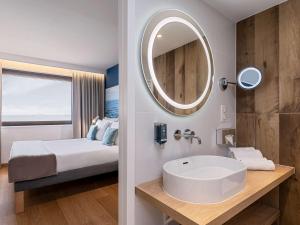 a bathroom with a sink and a mirror at Novotel Gdańsk Marina in Gdańsk