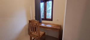 a wooden desk with a chair next to a window at MANDALIKA Homestay in Kuta Lombok