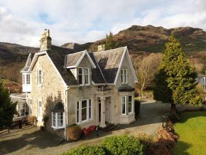 una vecchia casa con una montagna sullo sfondo di Rhumhor House a Carrick