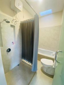 Un baño con ducha, inodoro y lavabo. en RB Villa, en Saba