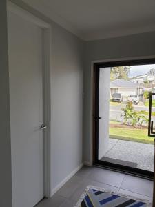 a room with a door with a view of a yard at Melaleuca Homestay in Bahrs Scrub