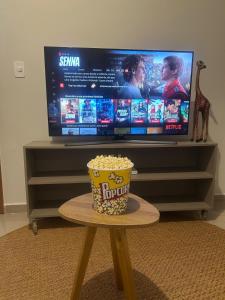 a bowl of popcorn sitting on a table in front of a tv at Joia do Mirante Estilo e Conforto Extrema Minas gerais in Extrema