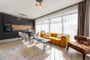 a living room with a yellow couch and a table at Magnolia Apartment Hotel in Budapest