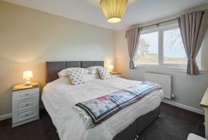 a bedroom with a large bed and a window at Host & Stay - Audrey's Cottage in Kirk Yetholm