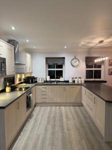 a kitchen with white cabinets and black counter tops at Gellyburn Cottage in Kinross
