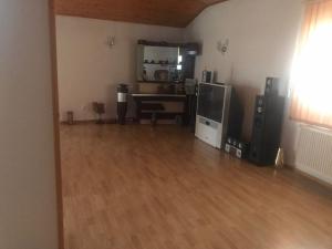 a living room with a hard wood floor and a television at Vila Elena in Bucharest +5 photos