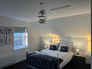 a bedroom with a bed with a light on the ceiling at Gellyburn Cottage in Kinross