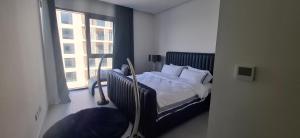 a bedroom with a bed and a large window at almoaj ,juman 2 marina view,level3 in Muscat